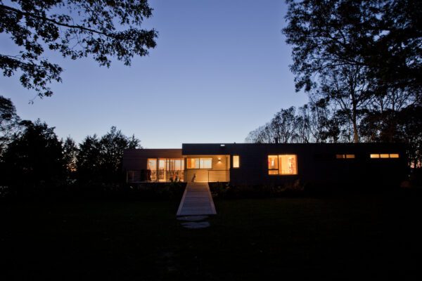 Sleek glass house on the Westport River, renovated using a faux Saltbox Colonial foundation